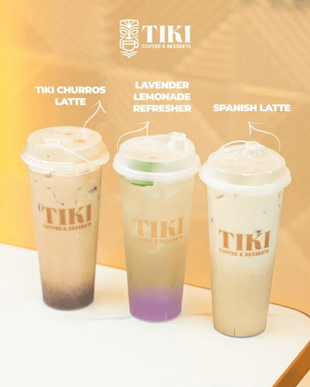 A lineup of specialty lattes and a refresher on a dark café counter