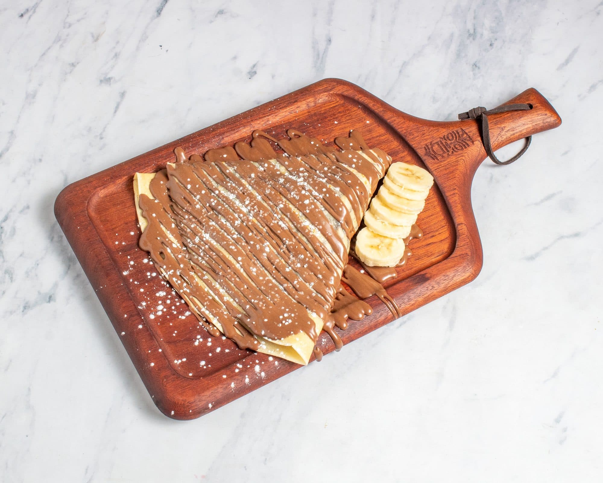 A banana and Nutella crepe dusted with powdered sugar