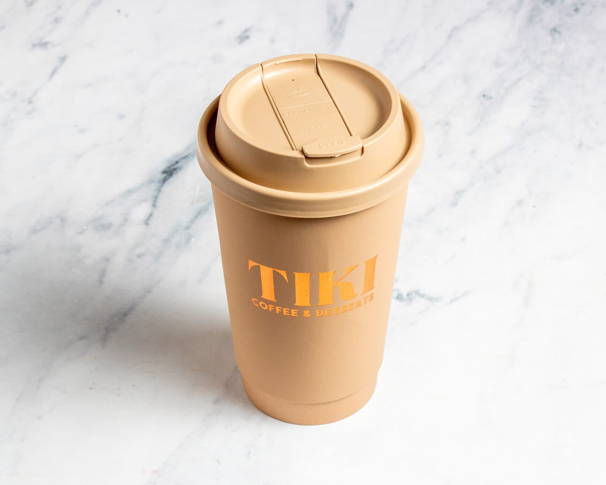 A hot latte in a Tiki to-go cup