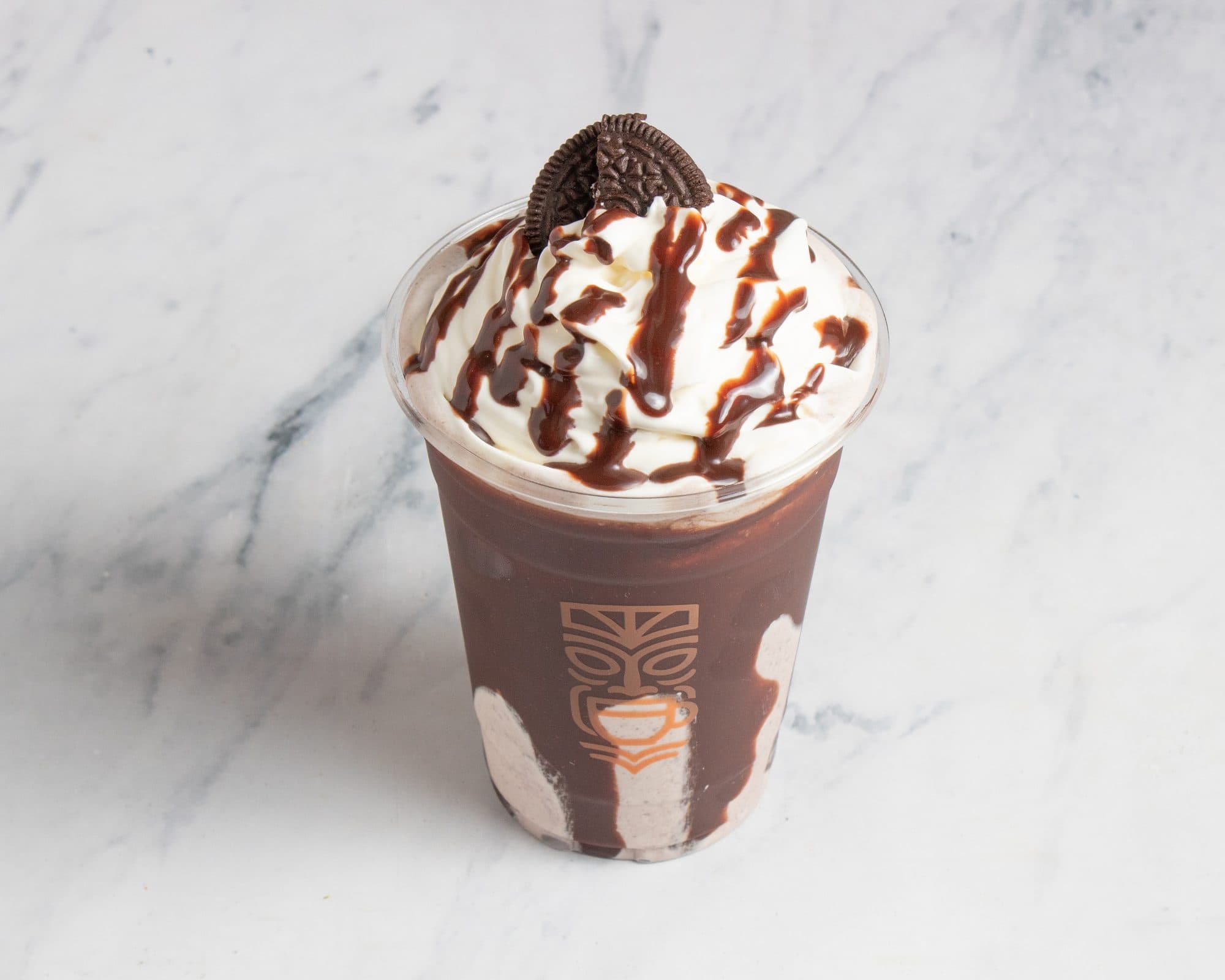 A chocolate shake topped with whipped cream, fudge drizzle, and an Oreo