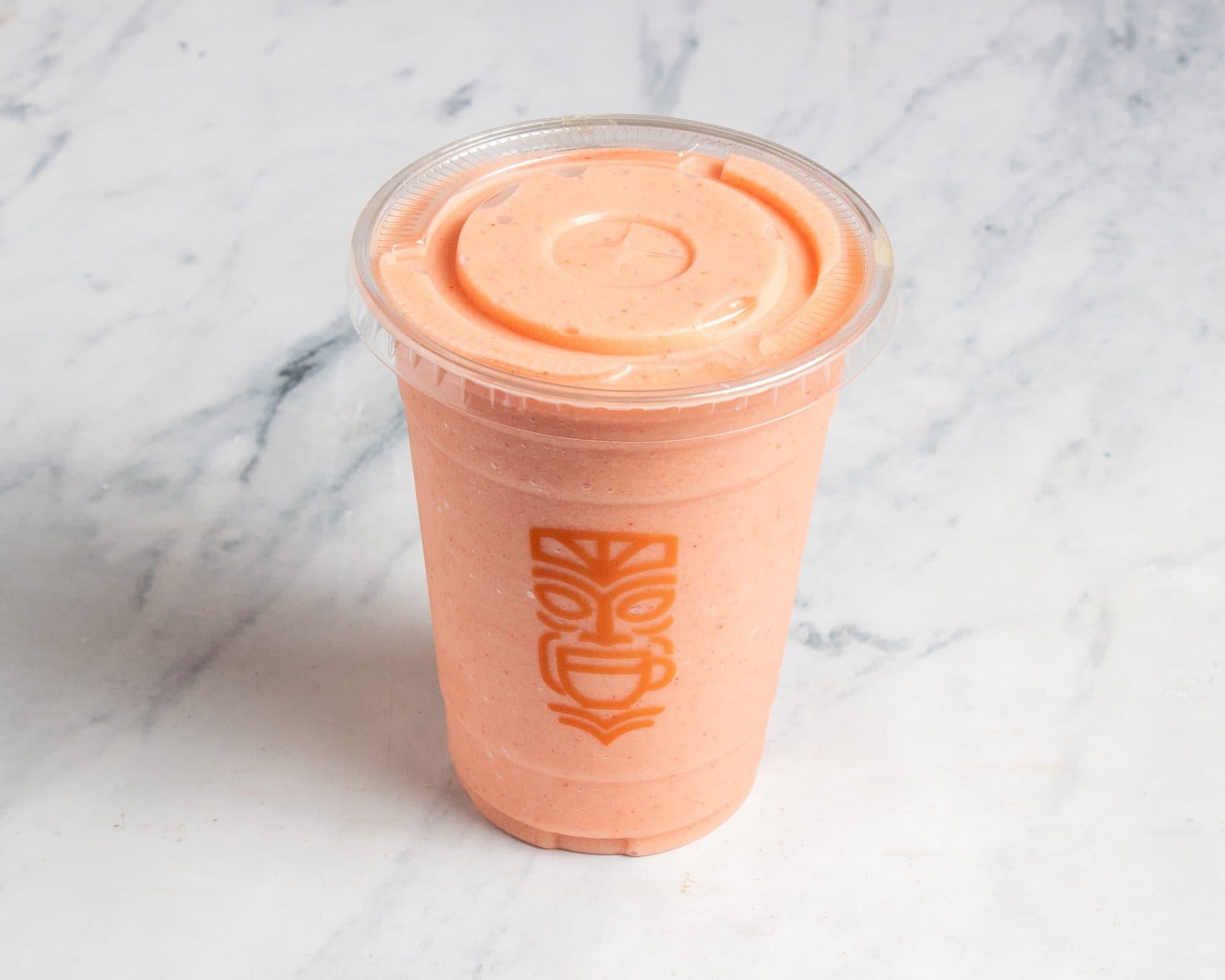 A tropical smoothie in a clear Tiki cup